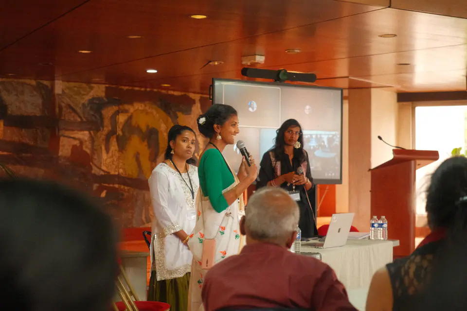 Two speakers present a workshop in front of a screen
