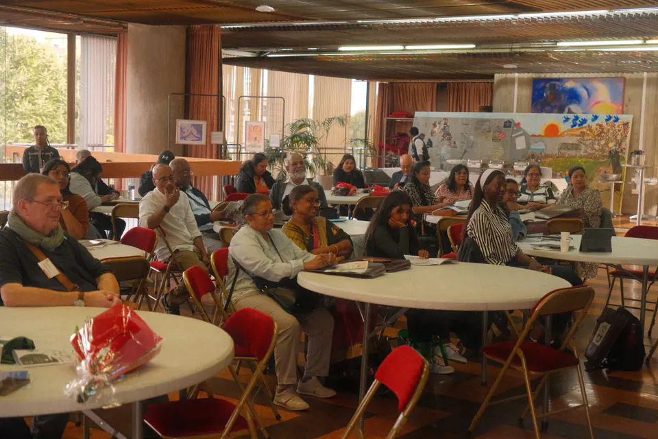 The audience seated at round tables in the reception hall